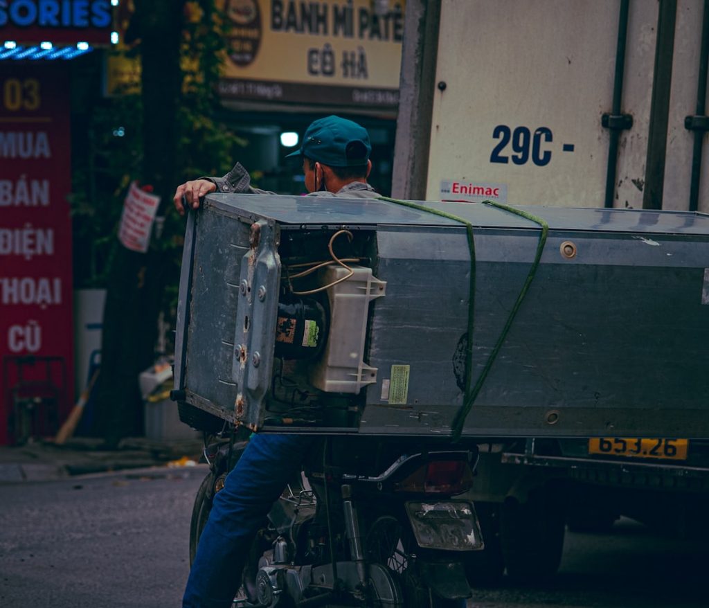 man-on-motorcycle-transports-large-appliance-on-truck-0z7y59oda2w